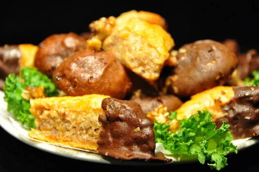 A plate of homemade desserts, chocolate covered baklava and cake slices